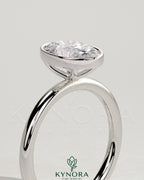 Elegant 2ct oval bezel solitaire engagement ring by Kynora CJ featuring a central oval diamond set in a sleek bezel setting.