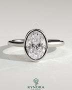 Kynora CJ 2ct oval bezel solitaire engagement ring with cathedral high setting, showcasing a sparkling oval diamond and elegant band.