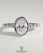 Kynora CJ 2ct oval bezel solitaire engagement ring with marquise and round accent stones, elegant gold band.