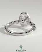 Kynora CJ 2ct oval bezel solitaire engagement ring with marquise and round accent stones, showcasing elegant jewelry design.