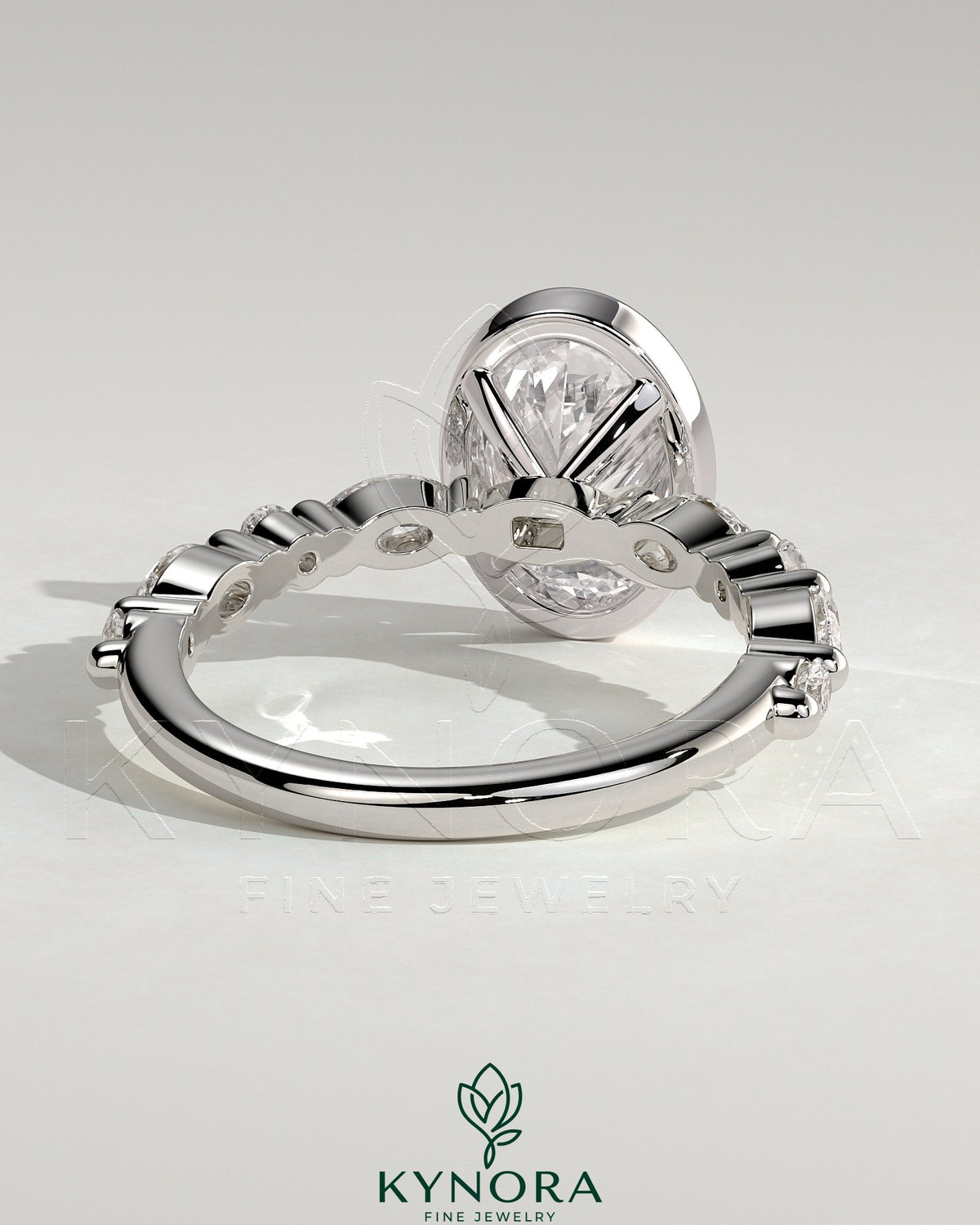 Kynora CJ 2ct oval bezel solitaire engagement ring with marquise and round accent stones, showcasing elegant jewelry design.