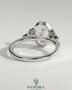 Kynora CJ 2ct oval bezel solitaire engagement ring with marquise and round shoulder stones in a cathedral high setting.