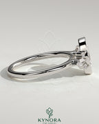 Kynora CJ 2ct oval bezel solitaire engagement ring with marquise and round shoulder stones in a cathedral high setting.