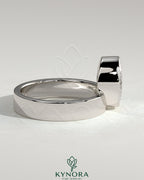 Kynora CJ 2ct oval bezel solitaire engagement ring with offset setting and flat cigar band, showcasing elegant gold jewelry design.