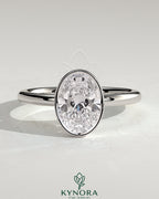 Kynora CJ 2ct oval bezel solitaire engagement ring with petal gallery design, showcasing a sparkling center stone and intricate band details.
