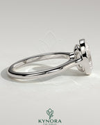 Kynora CJ 2ct oval bezel solitaire engagement ring with twisted gallery design, showcasing a sparkling oval diamond.