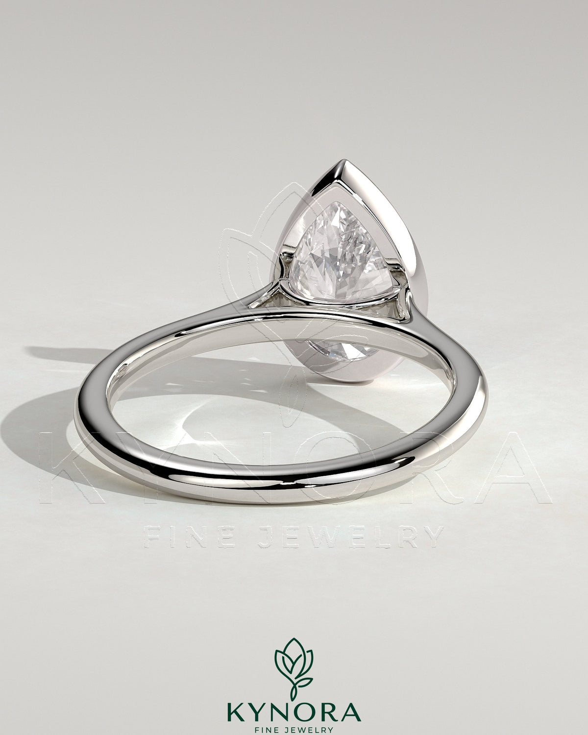 Kynora CJ 2ct pear-shaped diamond bezel solitaire engagement ring with cathedral high setting, showcasing elegant jewelry design.