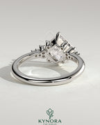 Kynora CJ 2ct princess cut solitaire engagement ring with angled bezel setting and clustered round shoulder stones.