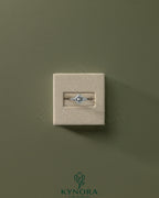 Kynora CJ 2ct princess cut diamond solitaire engagement ring with bezel setting and clustered shoulder stones.