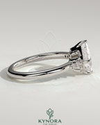 Kynora CJ 2ct princess claw solitaire engagement ring with angled bezel setting and clustered round shoulder stones.