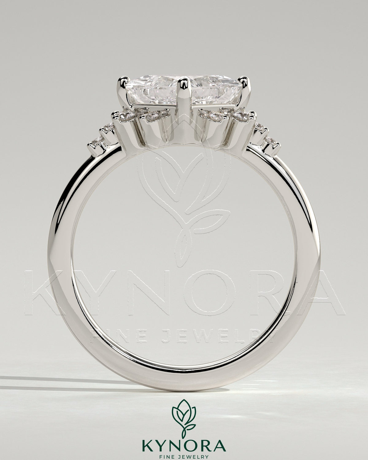 Kynora CJ 2ct princess cut diamond solitaire engagement ring with bezel setting, angled design, and round shoulder stones.