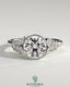 Kynora CJ 2ct round bezel solitaire engagement ring with clustered round and marquise shoulder stones in a detailed jewelry image.