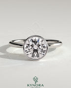 Kynora CJ 2ct round bezel solitaire engagement ring with petal gallery design, showcasing a sparkling diamond on a silver band.