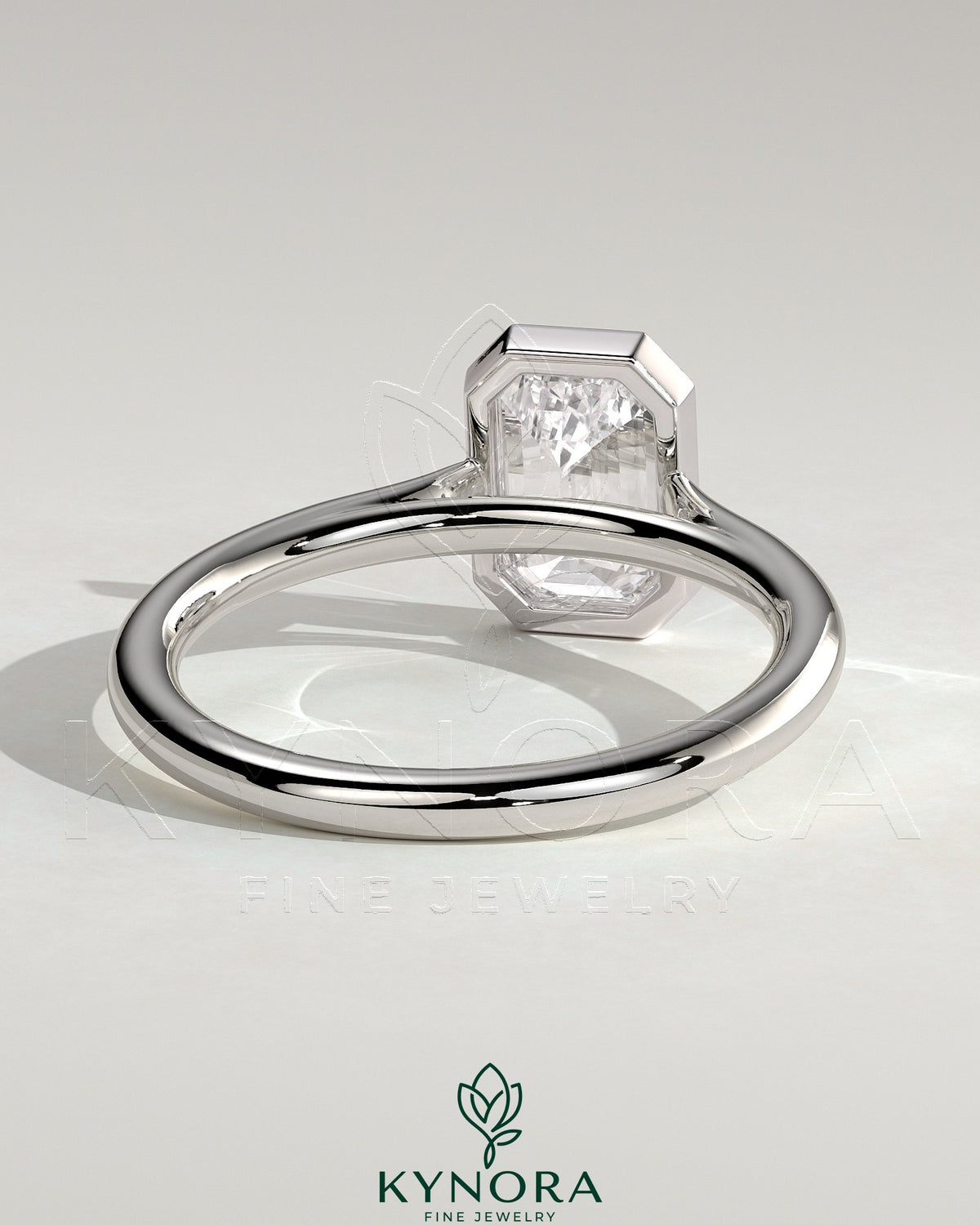 Kynora CJ statement 2ct emerald bezel solitaire engagement ring with open cathedral high setting showcasing a large central emerald gemstone.