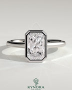 Kynora CJ statement 2ct radiant bezel solitaire engagement ring with open cathedral high setting and intricate band detail.
