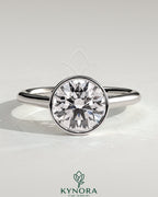 Kynora CJ statement 2ct round bezel solitaire engagement ring with open cathedral high setting, showcasing elegant jewelry design.