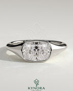 Kynora CJ 2ct elongated cushion cut diamond engagement ring with east-west bezel solitaire and signet band design.