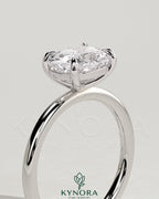 Elegant 2-carat elongated cushion cut east-west claw solitaire engagement ring by Kynora CJ, featuring a sparkling central diamond.