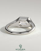 Kynora CJ 2ct emerald cut east-west bezel solitaire engagement ring with signet band showcasing a central emerald gemstone.