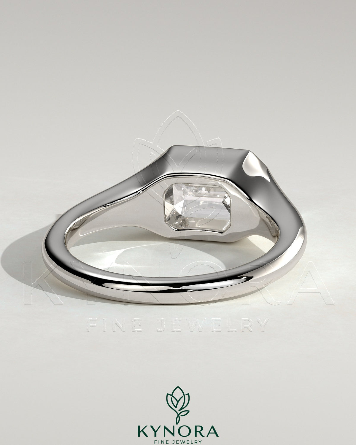 Kynora CJ 2ct emerald cut east-west bezel solitaire engagement ring with signet band showcasing a central emerald gemstone.