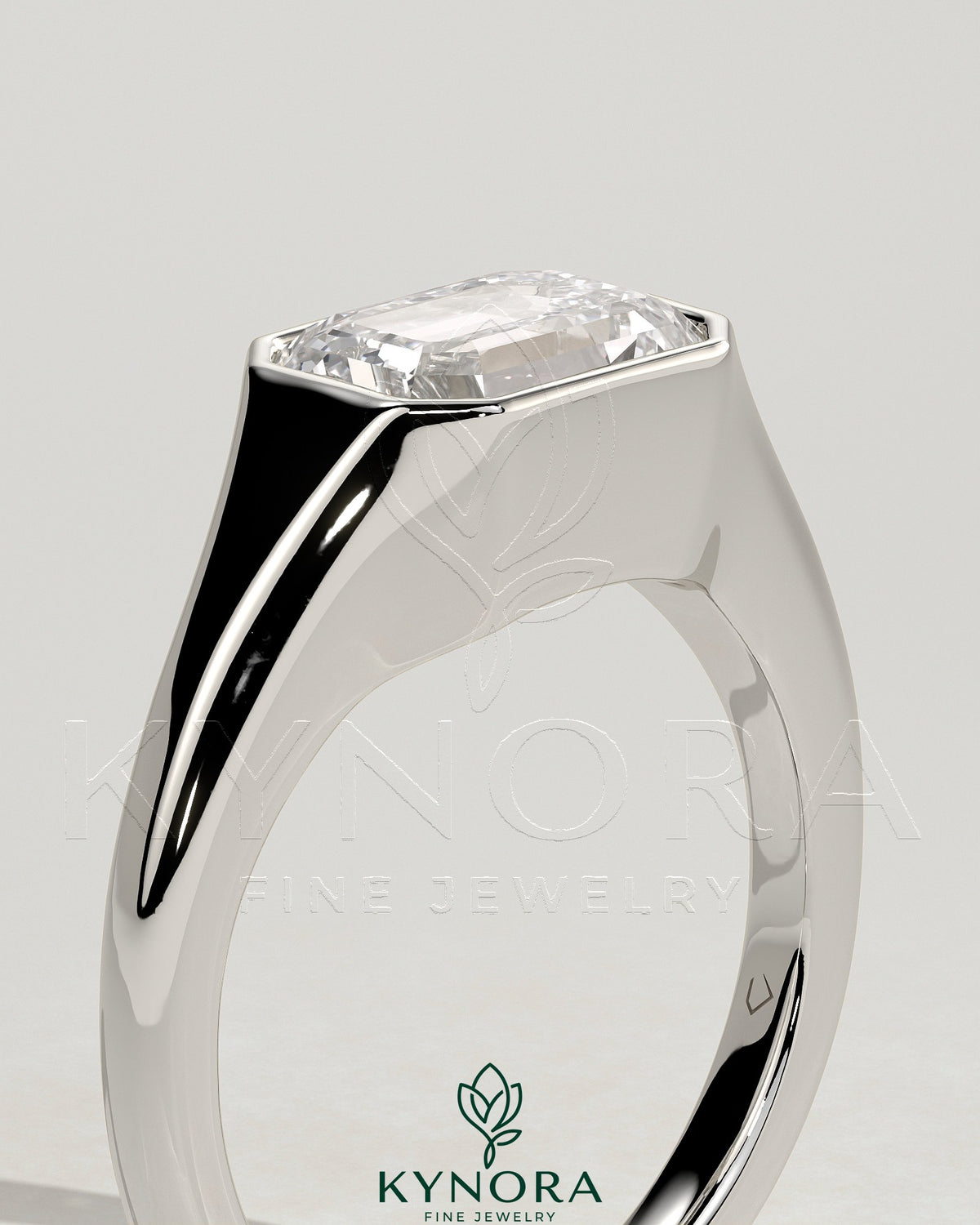 Kynora CJ 2ct emerald cut east-west bezel solitaire engagement ring with signet band featuring a central emerald gemstone.