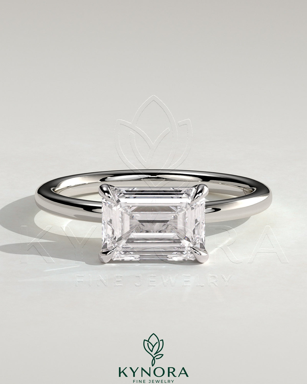 Kynora CJ 2ct emerald East-West claw solitaire engagement ring featuring a vibrant green emerald gemstone set horizontally.