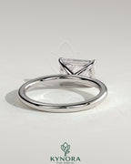 Kynora CJ 2ct emerald east-west claw solitaire engagement ring with a central emerald cut gemstone and sleek band design.
