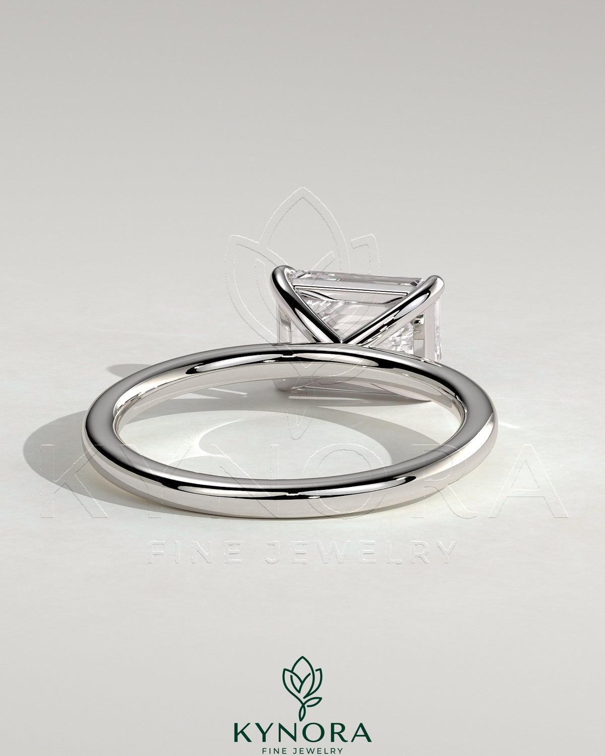 Kynora CJ 2ct emerald east-west claw solitaire engagement ring with a central emerald cut gemstone and sleek band design.