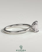 Kynora CJ 2ct emerald east-west claw solitaire engagement ring with a central emerald-cut gemstone and elegant band design.