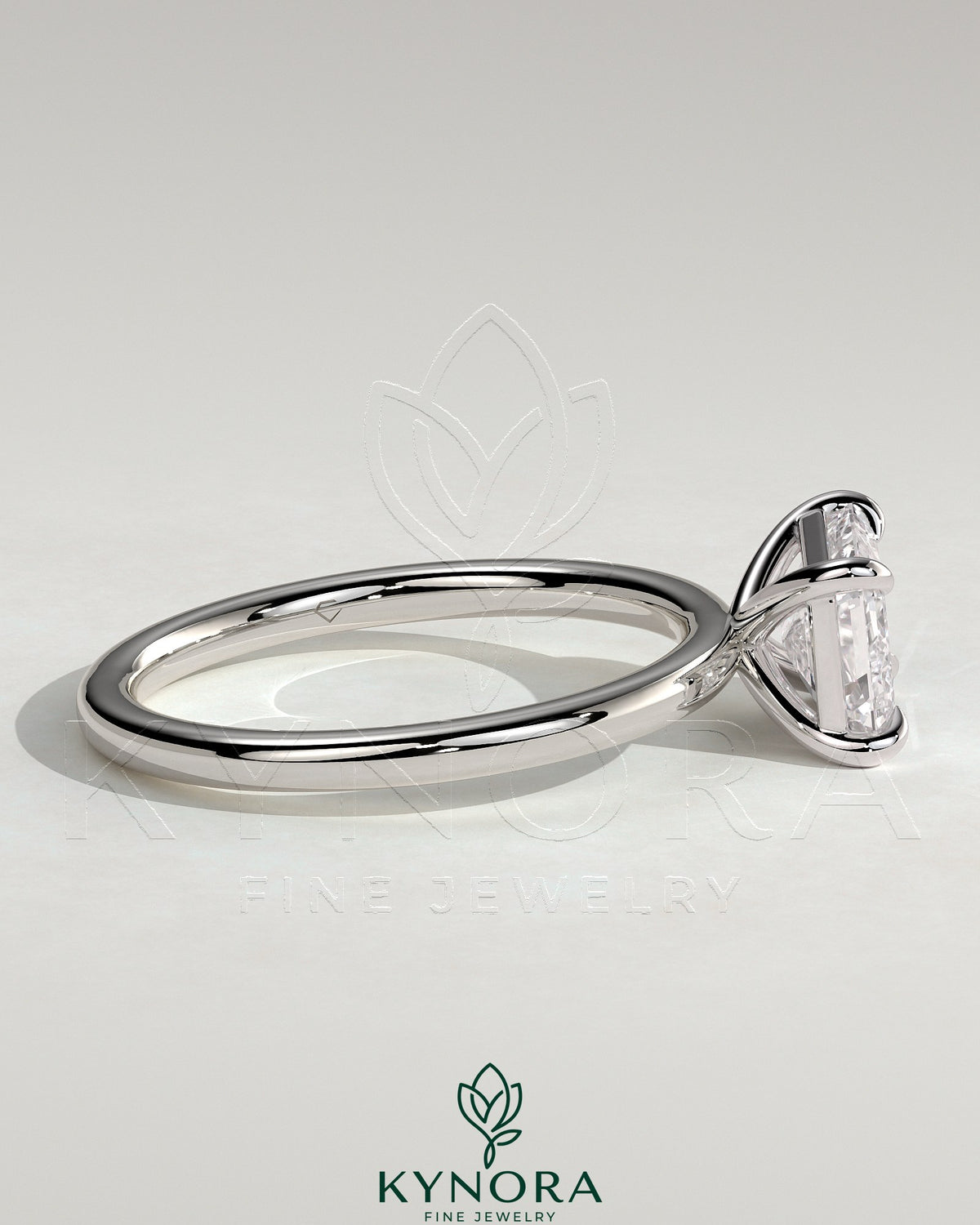 Kynora CJ 2ct emerald east-west claw solitaire engagement ring with a central emerald-cut gemstone and elegant band design.
