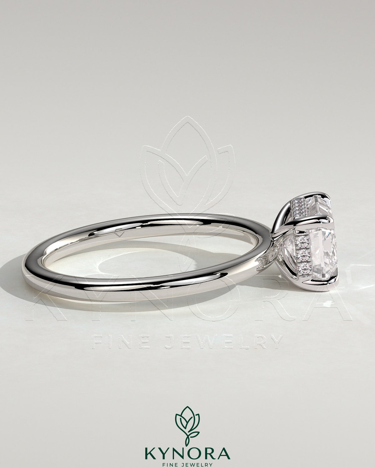Kynora CJ 2ct emerald cut east-west claw solitaire engagement ring with hidden halo and diamond accents on a silver band.
