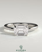 Kynora CJ 2ct emerald east-west claw solitaire engagement ring with raised basket gallery and intricate metalwork design