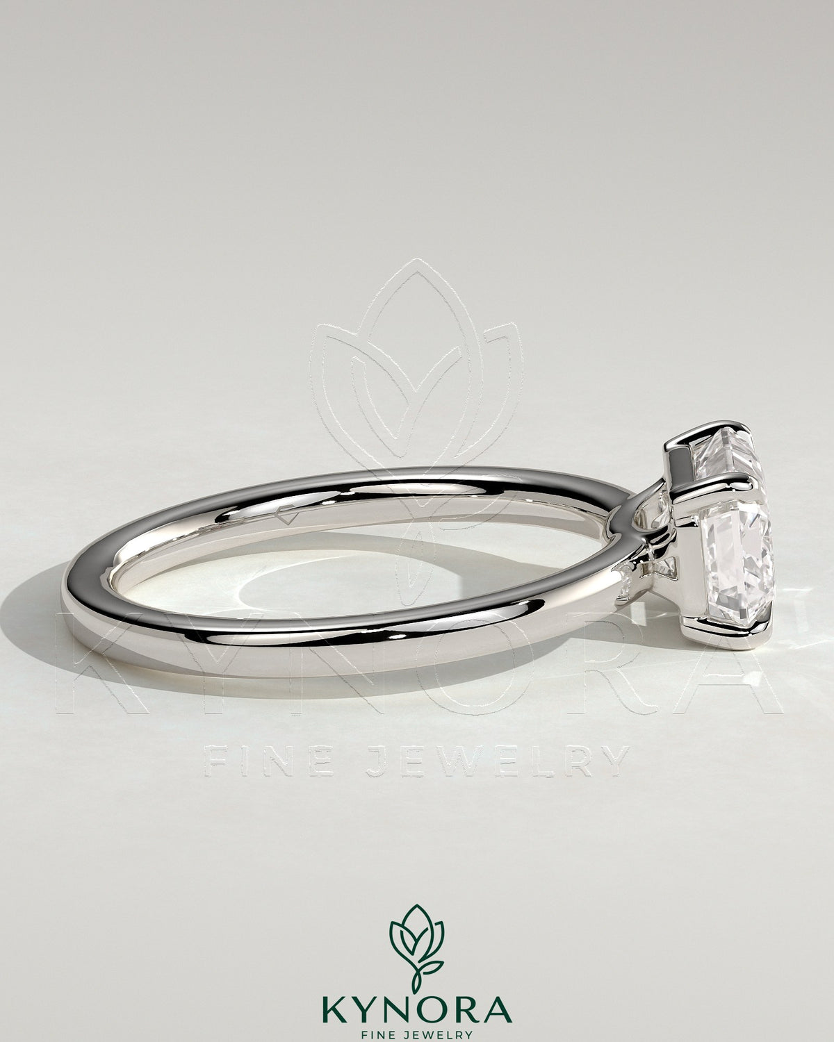 Kynora CJ 2ct emerald east-west claw solitaire engagement ring with raised basket gallery featuring a central emerald gemstone.