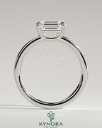 Kynora CJ 2ct emerald east-west claw solitaire engagement ring with raised basket gallery showcasing a vibrant emerald gemstone.