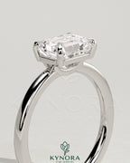 Kynora CJ 2ct emerald east-west claw solitaire engagement ring with raised basket gallery and detailed band design.
