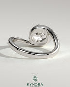 East-West 2ct oval diamond solitaire engagement ring with bypass band by Kynora CJ, showcasing the elegant design and sparkling gemstone.
