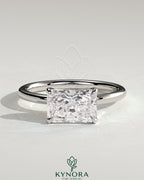 Kynora CJ 2ct radiant east-west claw solitaire engagement ring with a central diamond set horizontally on a sleek band.
