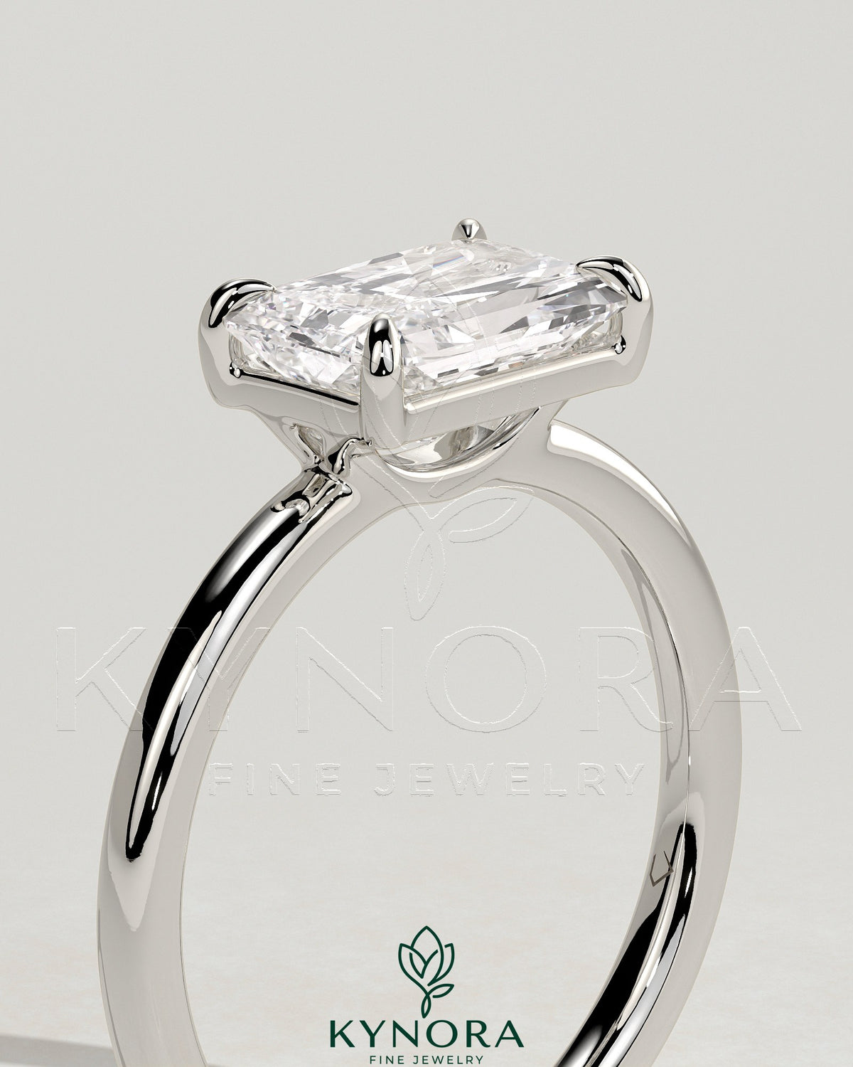 Kynora CJ 2ct radiant east-west claw solitaire engagement ring with raised basket gallery design, sparkling center stone.