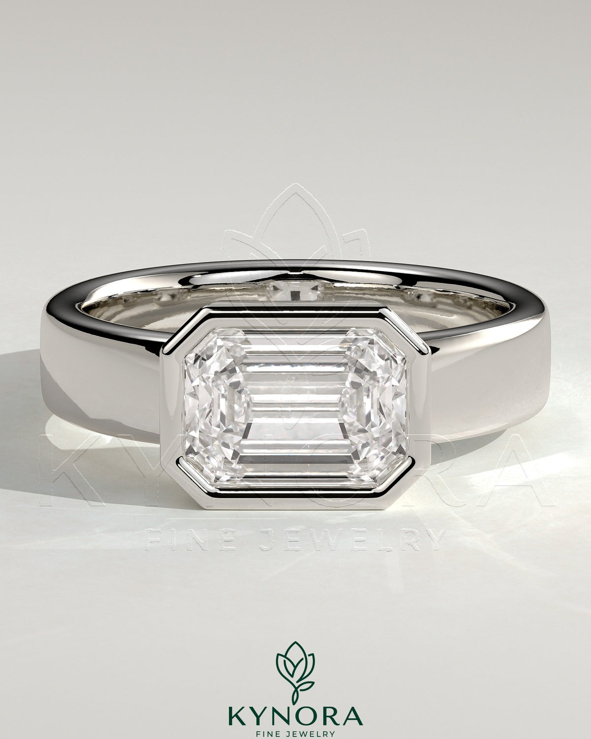 Kynora CJ statement 2ct emerald east-west bezel solitaire engagement ring with flat cigar band, featuring a prominent green emerald gemstone. Imagen principal del producto