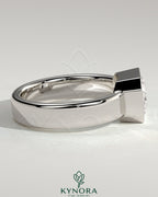 Kynora CJ statement 2ct emerald east-west bezel solitaire engagement ring with flat cigar band, showcasing a prominent green emerald.