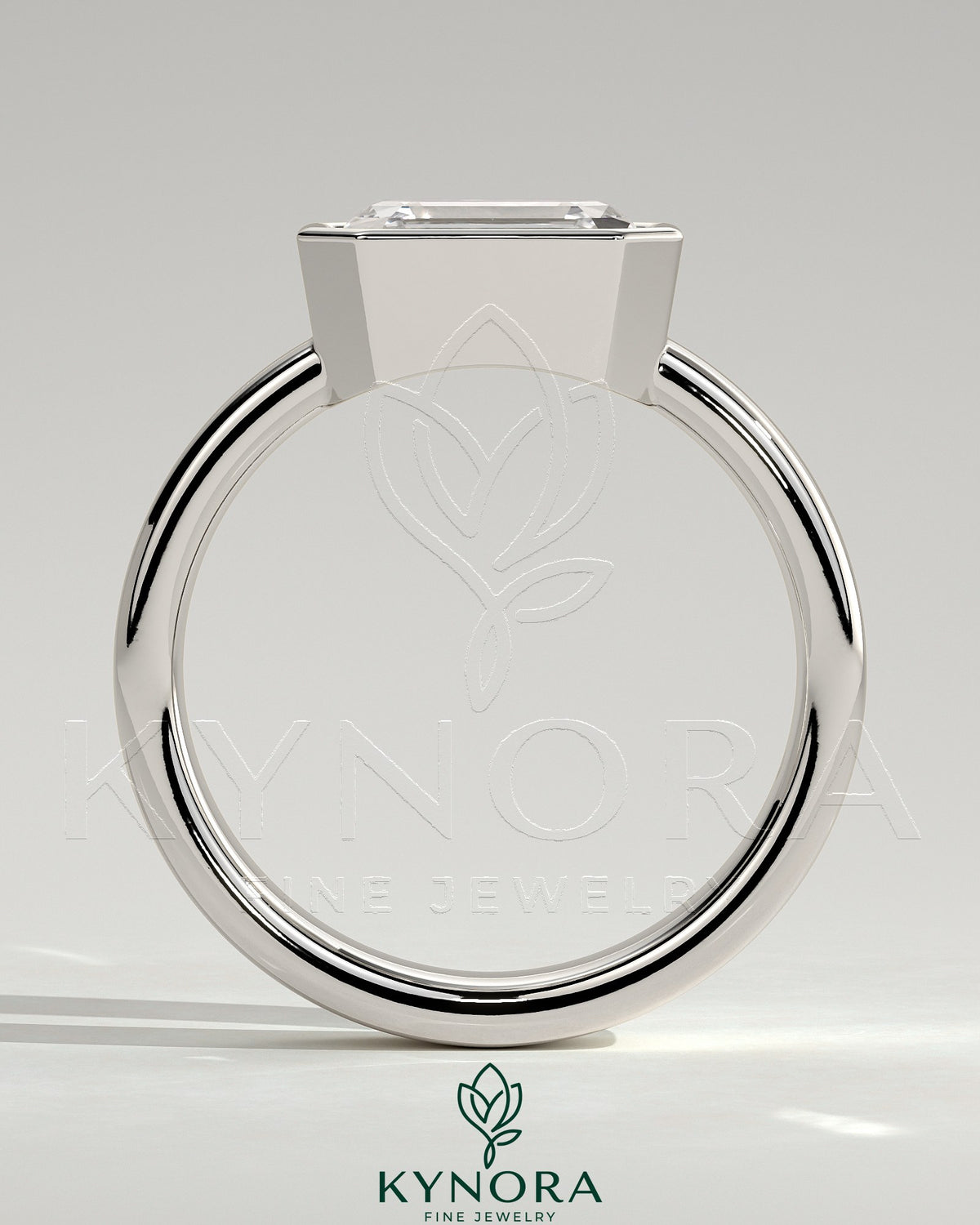 Kynora CJ East-West 2ct emerald bezel solitaire engagement ring with flat cigar band, showcasing a vibrant emerald gemstone and elegant design.
