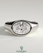 Kynora CJ statement 2ct oval east-west bezel solitaire engagement ring with signet band, featuring a prominent oval diamond.