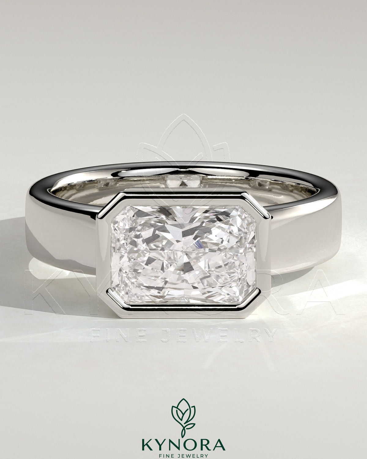 Kynora CJ radiant 2ct east-west bezel solitaire engagement ring with flat cigar band, featuring sparkling center stone and sleek design. Imagen principal del producto