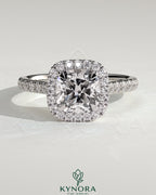 Kynora CJ 2ct cushion cut solitaire halo engagement ring with pave band and cathedral high setting, showcasing intricate detail.