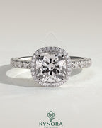 Kynora CJ 2ct cushion cut halo engagement ring with pave band and claw setting, featuring sparkling diamonds.