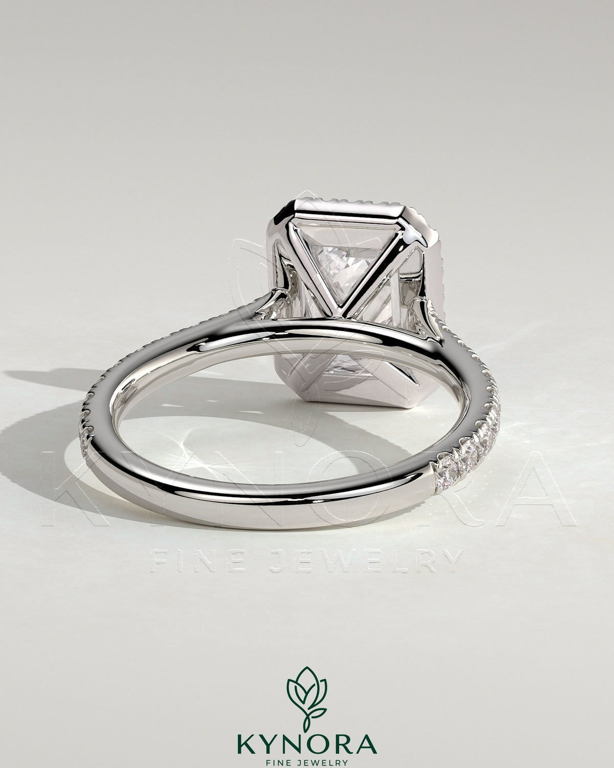 Kynora CJ 2ct emerald claw solitaire engagement ring with halo, pave band, and cathedral high setting.