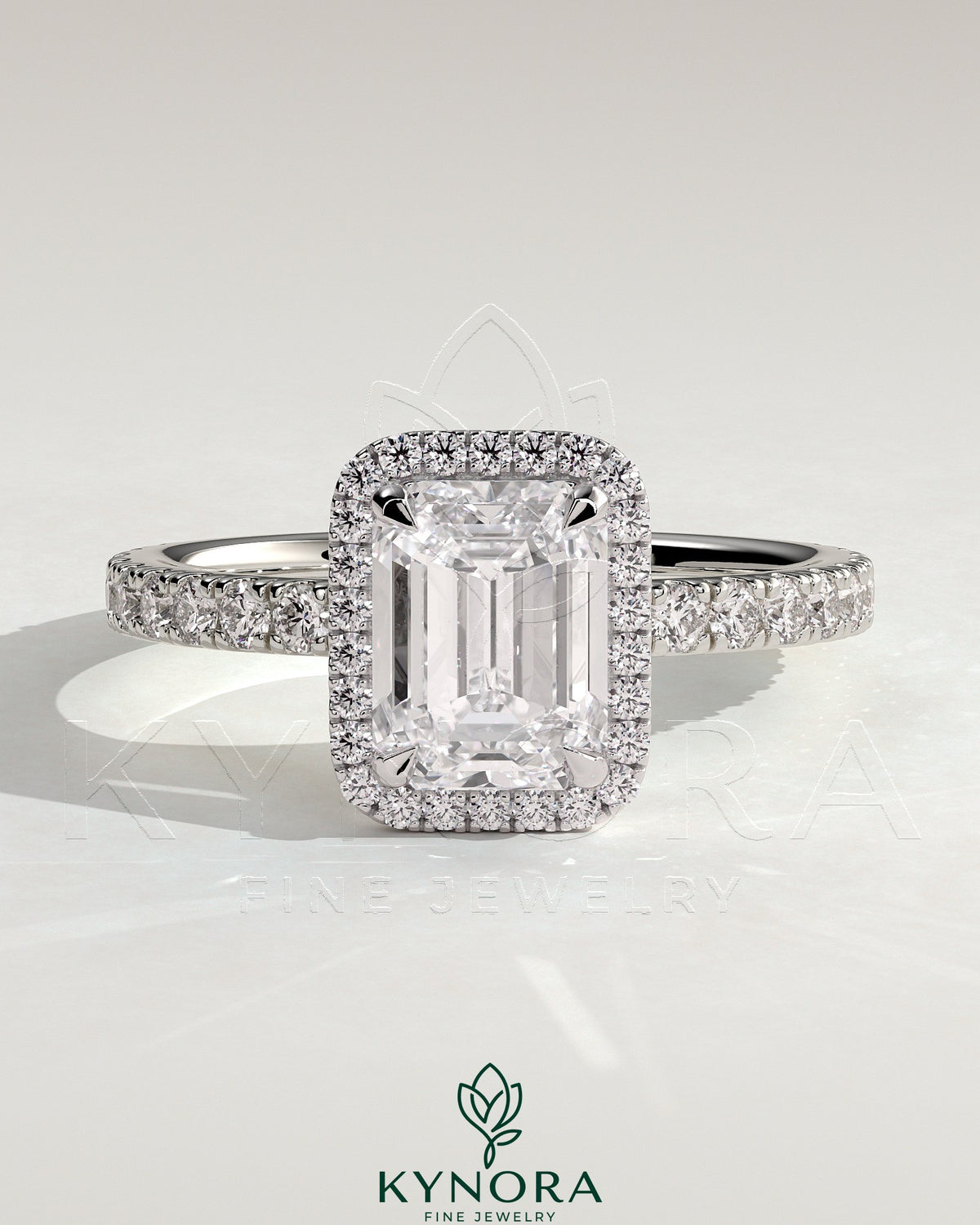 Kynora CJ 2ct emerald cut solitaire halo engagement ring with pave band, showcasing a sparkling emerald gemstone and intricate design.