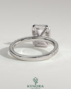 Kynora CJ 2ct emerald halo solitaire engagement ring with pave band, showcasing a central emerald-cut gemstone and intricate detailing.