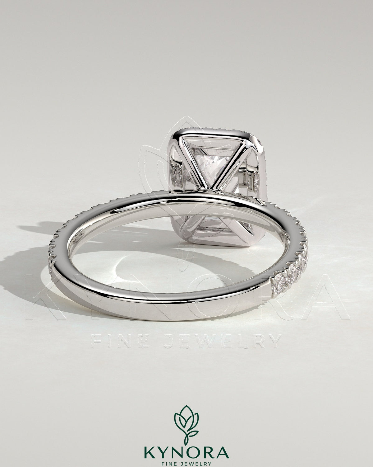 Kynora CJ 2ct emerald halo solitaire engagement ring with pave band, showcasing a central emerald-cut gemstone and intricate detailing.