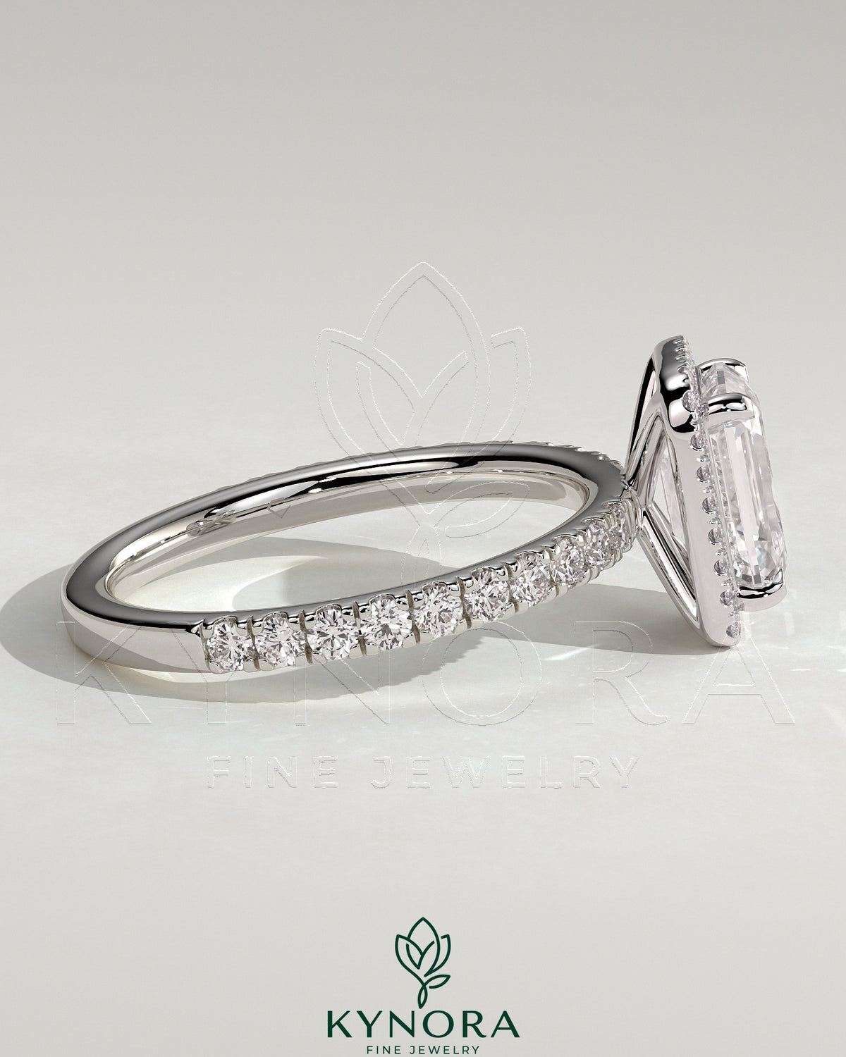 Kynora CJ 2ct emerald claw solitaire engagement ring with halo and pave band, showcasing sparkling diamonds and intricate design.